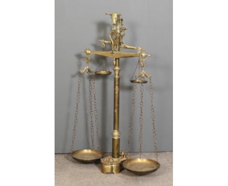 A 19th Century butchers polished brass balance scales with cast bulls head terminal turned column, on shaped base with weight