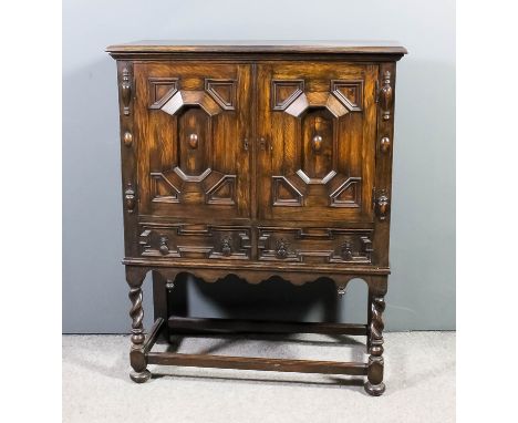 A 1920s panelled oak cabinet of "17th Century" design, with moulded edge to top, fitted one shelf enclosed by a pair of doors