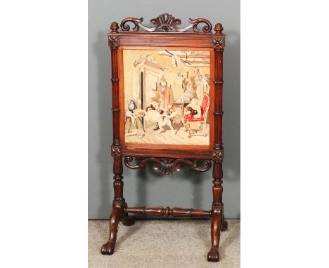 An early Victorian rosewood framed rectangular firescreen with carved scroll cresting, inset with Berlinwork panel of a cotta