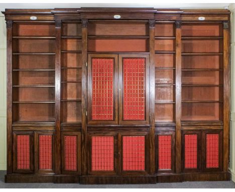 A mahogany break-front bookcase of Georgian design with deep moulded cornice, the frieze applied with three plaques lettered 