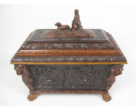 A 19th Century Irish Tea Caddy of sarcophagus shape with panels of figures and deer in landscape, animal mask corners, hunter