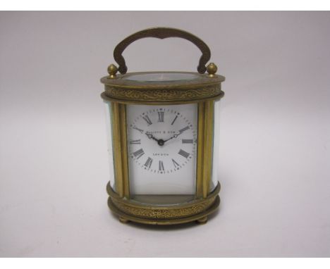 A small brass cased oval Carriage Clock with white enamel dial inscribed Elliott & Son, London, lever escapement, the case wi
