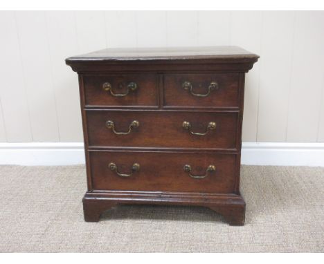 An 18th Century oak Box Commode with hinged lid above two short and two long simulated drawers on bracket feet, 20 in