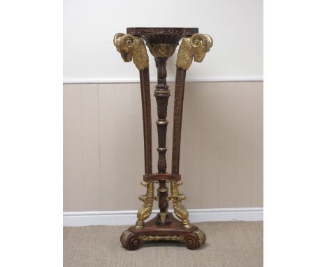 A Regency style mahogany Torchere with three ram's head terminals, central turned and carved column on tripod base with scrol