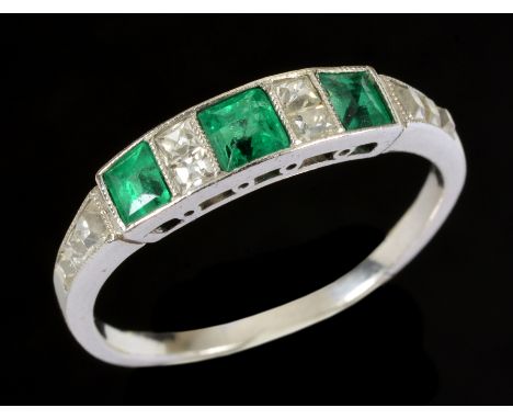 An Emerald and Diamond Ring millegrain-set three step-cut emeralds interspersed with pairs of cushion-cut diamonds, graduated