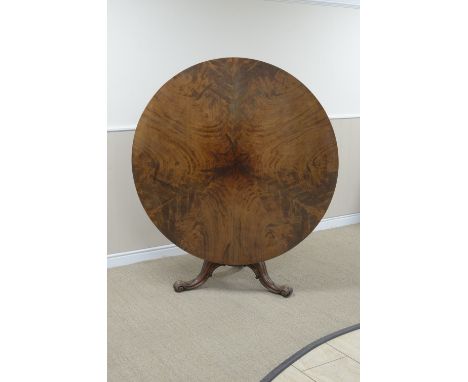 An early Victorian mahogany Breakfast Table with finely figured segment veneered circular top on bulbous column, scroll tripo