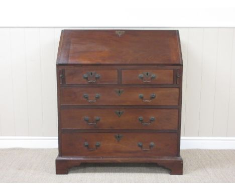 A George III mahogany Bureau with interior pigeon holes and drawers above two short and three long drawers on bracket feet, 2
