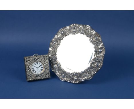 An Edward VII silver framed circular Easel Mirror with floral and scroll embossing, Sheffield 1904, 10 1/2 in, and a Travelli