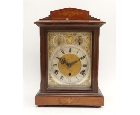 A Kienzle mahogany cased chiming bracket clock, with a bevelled edged glass door protecting a silvered chapter ring featuring