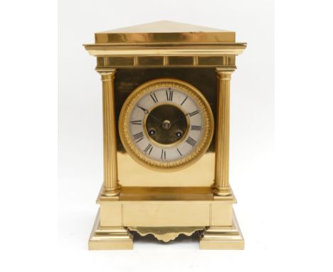 A 20th Century brass cased mantel clock, with a silvered chapter dial featuring Roman Numerals, in a circular scrolling frame