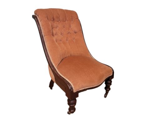 A Victorian spoon back armchair, having scroll arm terminals the button back upholstered in pale pink velvet, raised on turne