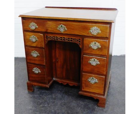 Georgian mahogany kneehole desk, the rectangular top with ledgeback and moulded edge, over a recess cupboard, blind fret frie