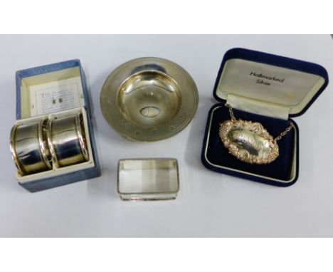 Three Birmingham silver napkin rings, a silver Brandy decanter label and a QEII silver armada dish, (5) 