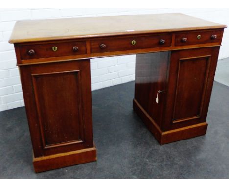 19th century mahogany desk, the rectangular top with rounded edges, over three frieze drawers, with panelled cupboards to the