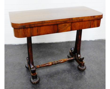 Regency rosewood foldover card table, with a green baize interior on scrolled side supports with turned stretcher and lotus b