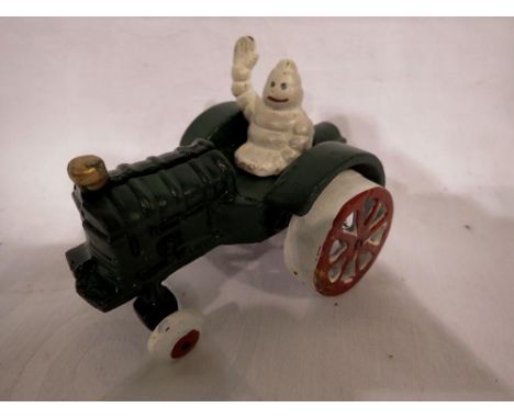 Cast iron Michelin Man on a tractor, H: 80 mm. UK P&amp;P Group 1 (£16+VAT for the first lot and £2+VAT for subsequent lots) 