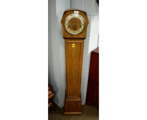 A 1930's walnut grandmother clock, the gilt chapter ring with Arabic numerals in black, within a shaped hood over a straight 