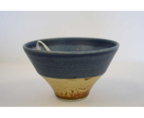 A studio porcelain small footed bowl in the manner of Lucie Rie, with blue and buff matte glazed bands, indistinct monogram, 