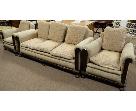 An early 20th Century three piece suite, comprising three seater sofa and a pair of armchairs, each with floral and butterfly