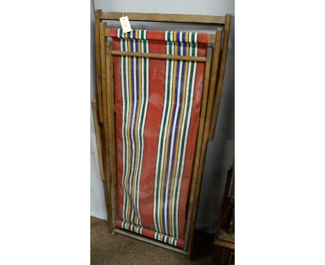 Two various vintage folding deck chairs, each with striped upholstery.