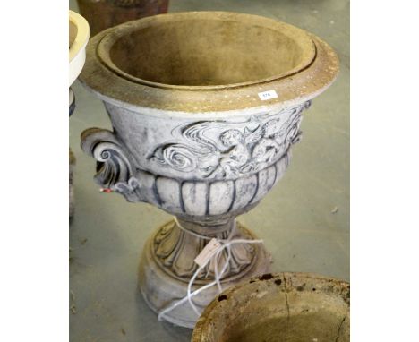 A stone composite urn garden planter, of twin-handled pedestal form, with half-gadrooned body below a frieze illustrating two