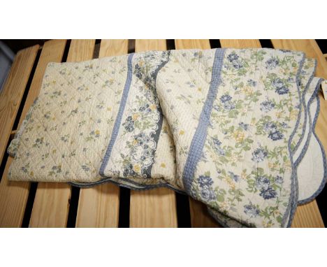 A coverlet or quilted blanket, in a patchwork of vintage floral and check; and other textiles.