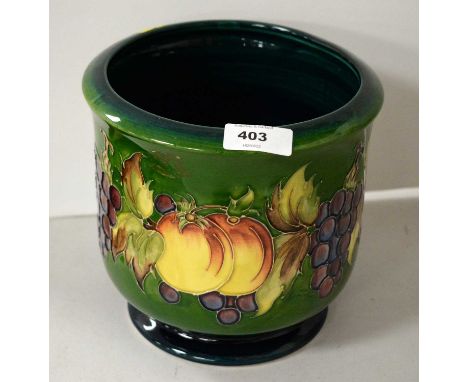 A Moorcroft fluted planter, decorated with fruiting vines and pairs of peaches, on green ground, impressed mark and painted m