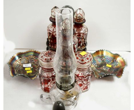 A set of three clear and cranberry glass decanters and stoppers, each decorated with stylized fruiting vines, contained in a 