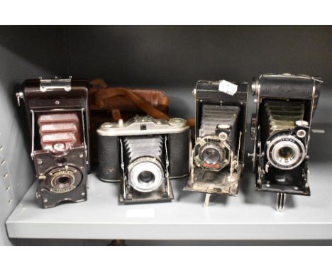 Four early 20th century photographic cameras including Agfa, Kodak and Soho model B.