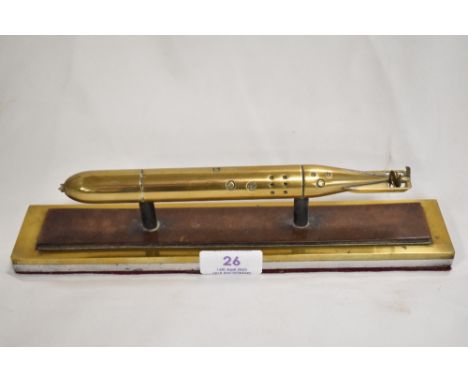 A fine desk top paper weight or replica model of a military Naval torpedo. Machined in brass and set on a heavy metal base. 2