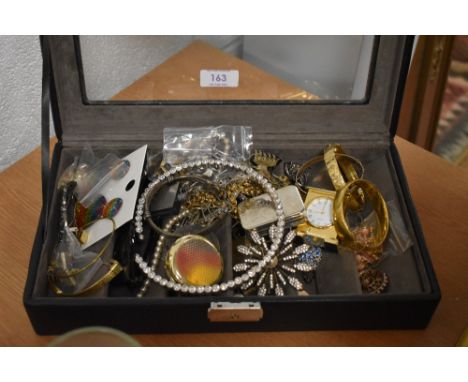 A case full of vintage costume jewellery including yellow metal bangles, a small clock and ear rings etc.