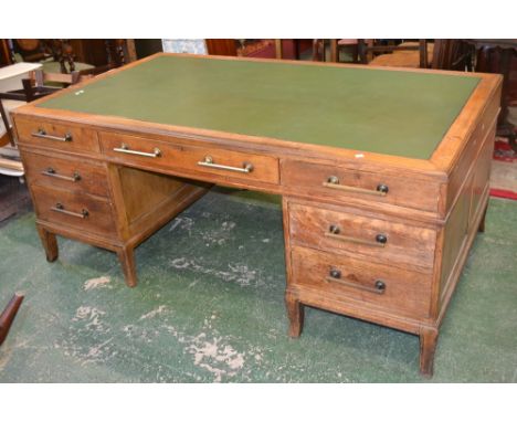 A large oak pedestal desk, leather inlaid caddy top, one long and two short drawers to frieze, kneehole flanked by two drawer