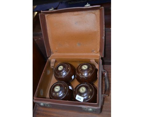 A pair of carpet bowls; another; a brown leather case