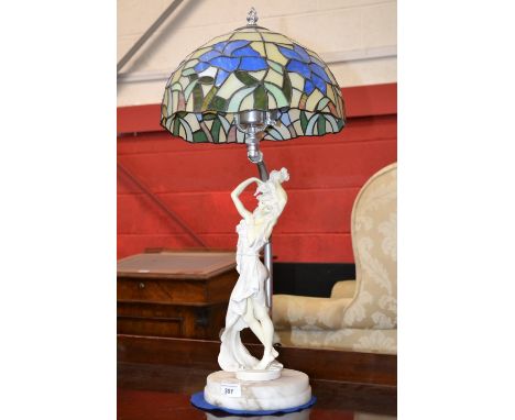 Table lamp with Tiffany style lamp shade, marble base decorated with scantily clad lady figure 
