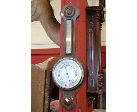 A Lancaster and Thorpe Ltd banjo barometer, silver scale and dial, carved oak case c.19020/1940