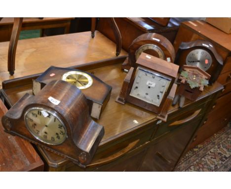 An Art Deco oak mantel clock; another, mahogany; others, similar; a Black Forest cuckoo clock (6)