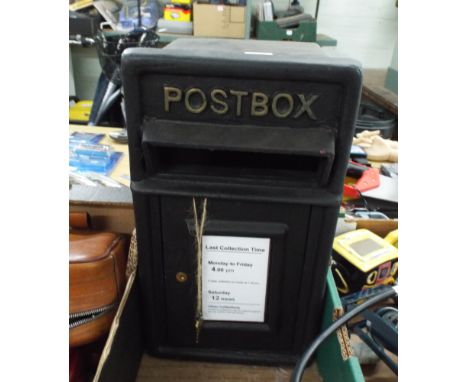 A wall mounted black post box with bracket