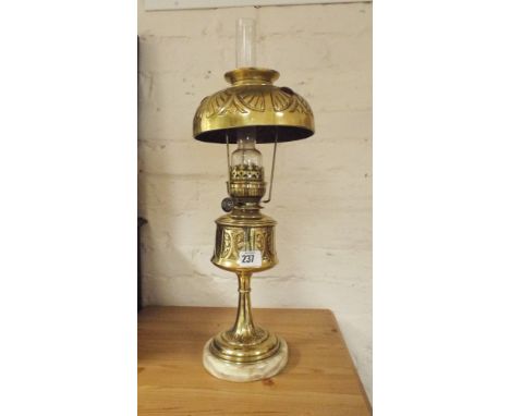 A brass and marbled based oil lamp with a be-jeweled brass shade
