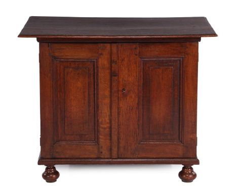 Oak cupboard with panel doors behind which a drawer and standing on ball legs, Holland early 19th century, 77 cm high, 98 cm 