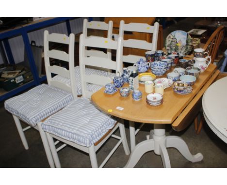 A drop leaf table together with a set of four ladder back chairs