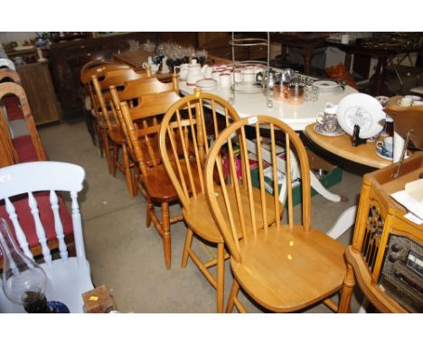 Two beech stick back chairs together with three pine dining chairs