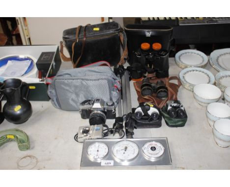 A barometer together with various pairs of binoculars; Olympus camera etc