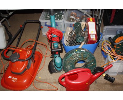 A quantity of garden tools; a roll of as new hose pipe; watering can
