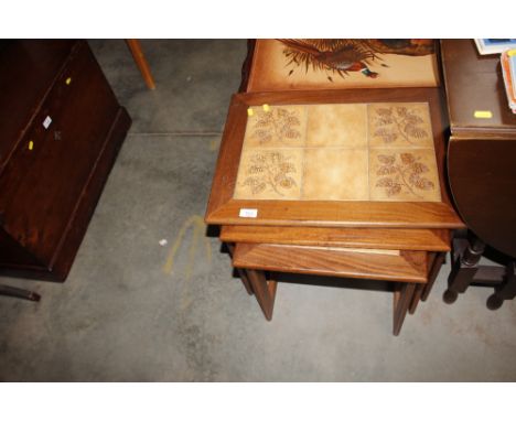 A nest of three teak and tile topped occasional tables