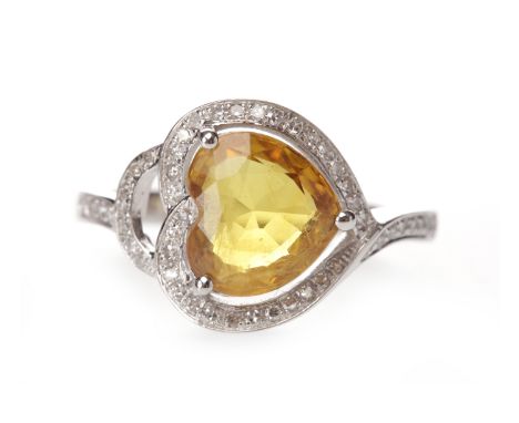 YELLOW SAPPHIRE AND DIAMOND RINGset with a heart shaped sapphire of approximately 2.45 carats, surrounded by round brilliant 