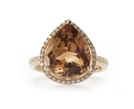 TOPAZ AND DIAMOND RINGset with a brown pear shaped topaz 12.5x10.9mm, surrounded by a halo of round brilliant cut diamonds, o