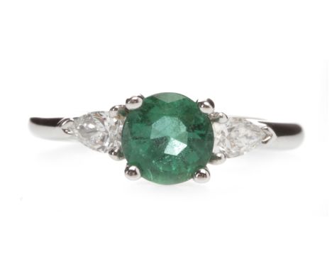 EMERALD AND DIAMOND THREE STONE RINGset with a central round emerald of approximately 1.05 carats flanked by two pear shaped 