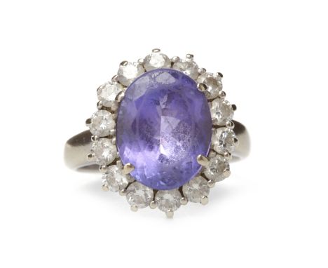 TANZANITE AND DIAMOND CLUSTER RINGset with a central oval tanzanite 12.3mm long and surrounded by round brilliant cut diamond