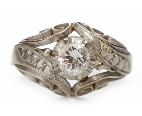 MID TWENTIETH CENTURY DIAMOND SINGLE STONE RINGwith an ornate openwork bezel formed in the round by scroll motifs and texture