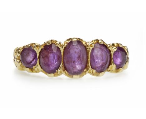 EIGHTEEN CARAT GOLD GEM SET FIVE STONE RINGwith graduated purple gems, pierced gallery, on ornate shoulders, size M, 4.5g